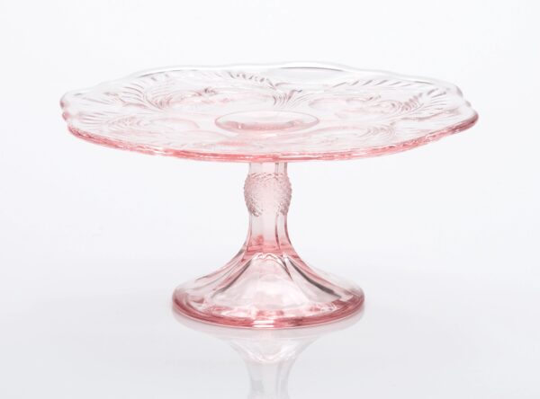 Elegant pink glass cake stand with decorative etching.