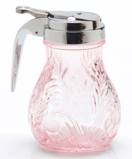 A pink glass syrup dispenser with a metal lid and handle.