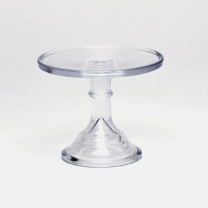 Clear acrylic cake stand with pedestal base on white background.