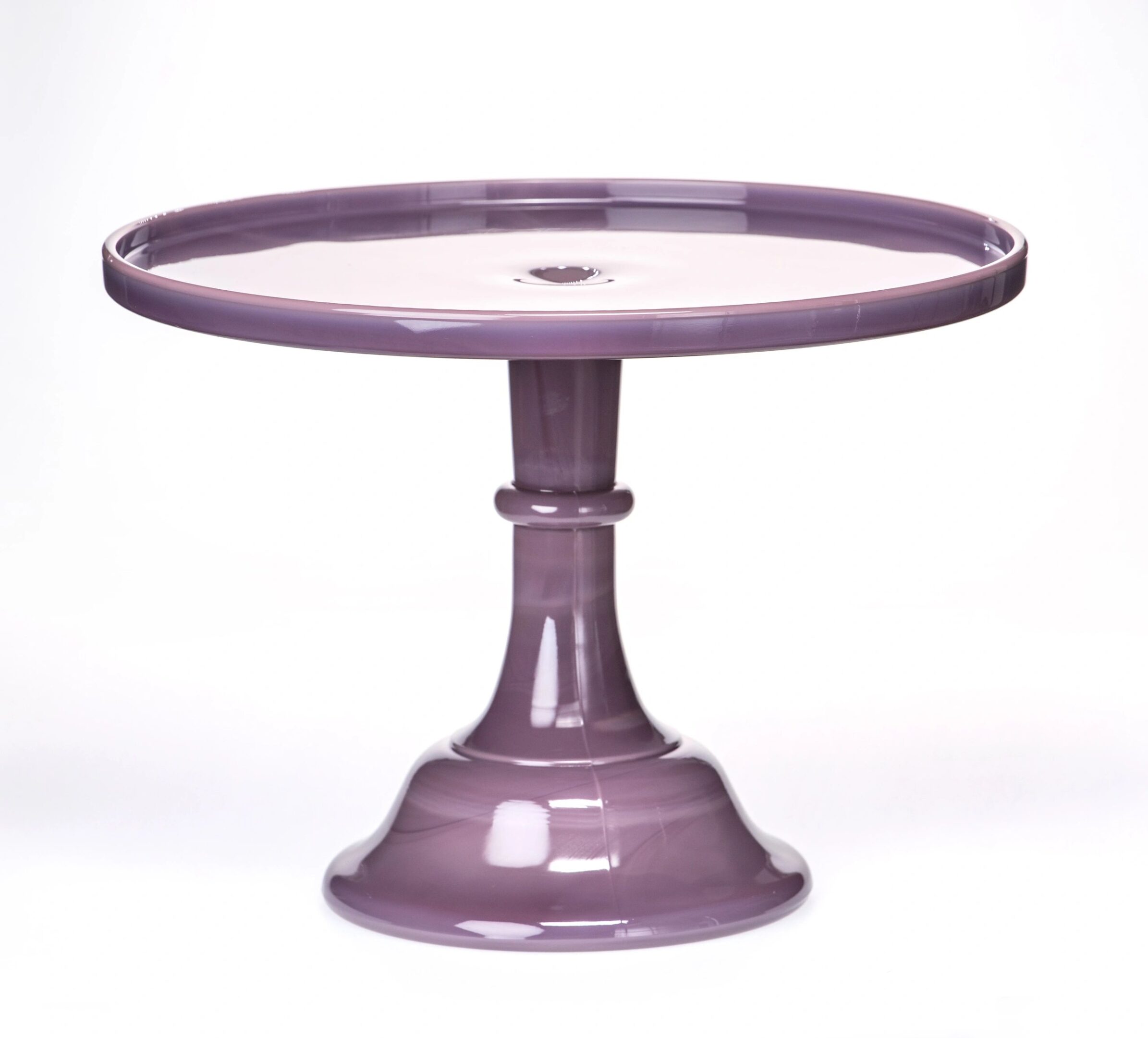 Purple ceramic cake stand with a pedestal base and round top.