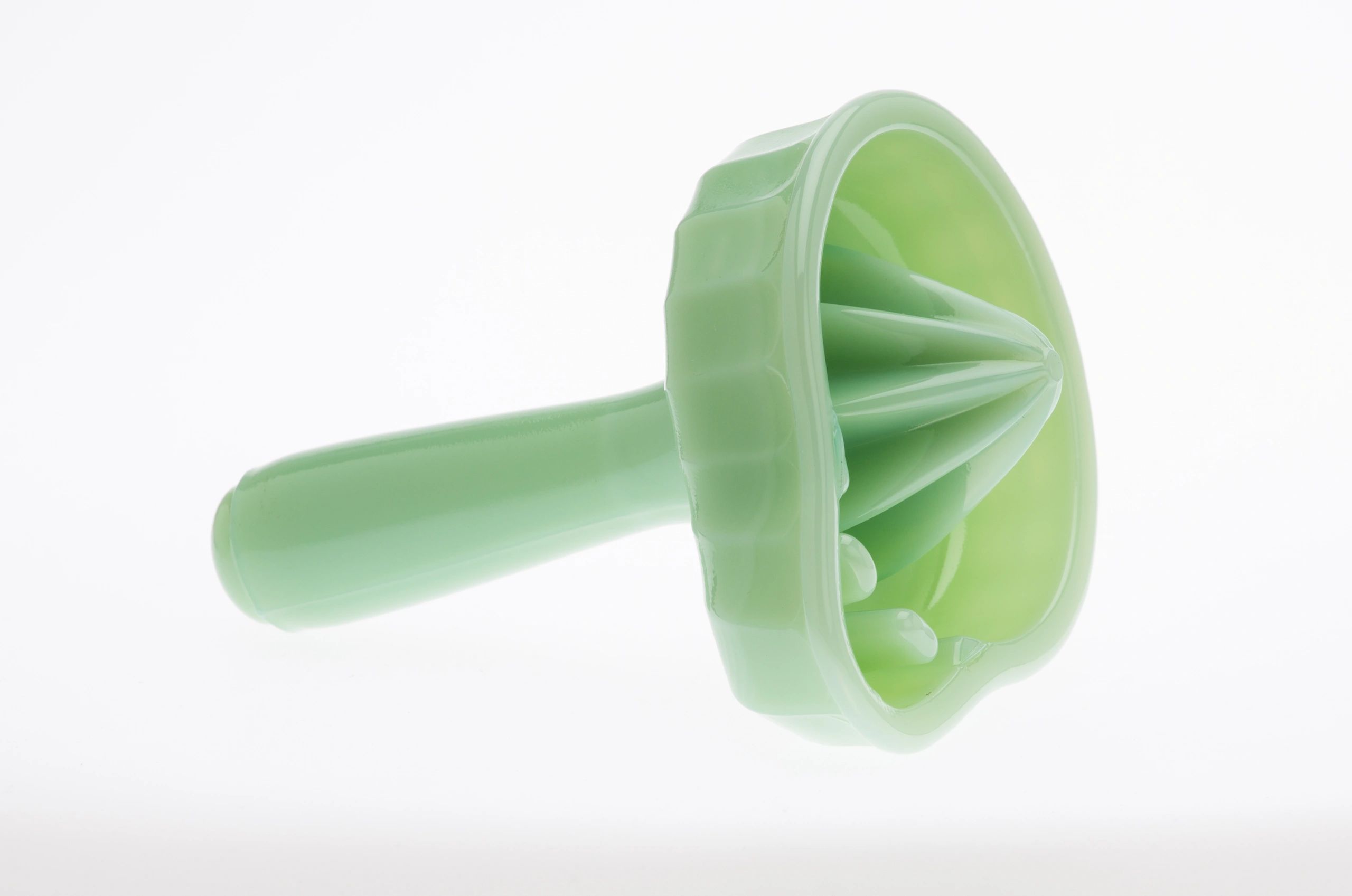 Green plastic citrus juicer with ridged reamer and handle.