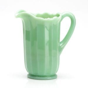 Green ceramic pitcher with a handle and spout.