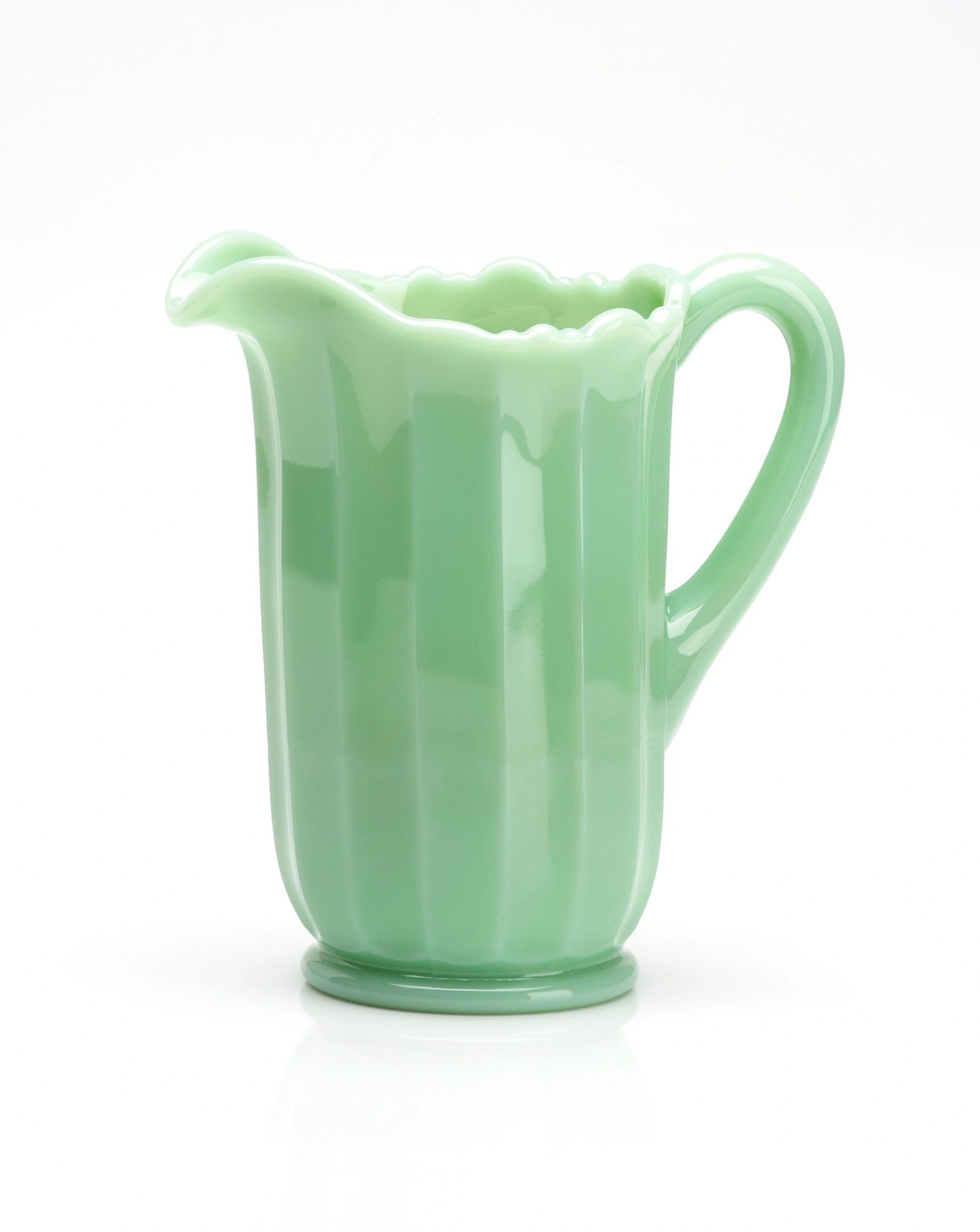Green ceramic pitcher with a handle and spout.