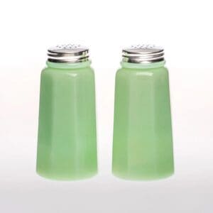 Pair of green glass salt and pepper shakers with metal lids.