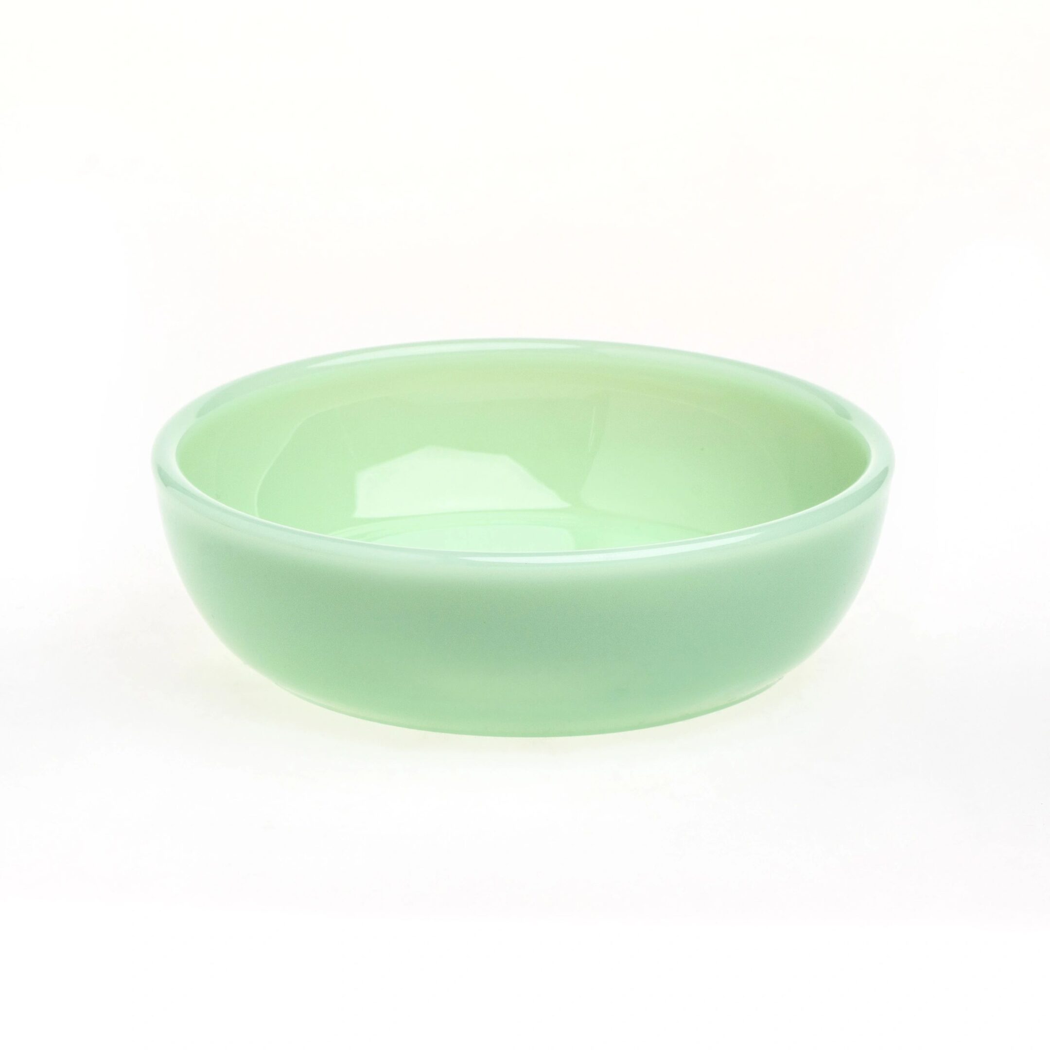 A simple light green ceramic bowl on a white background.