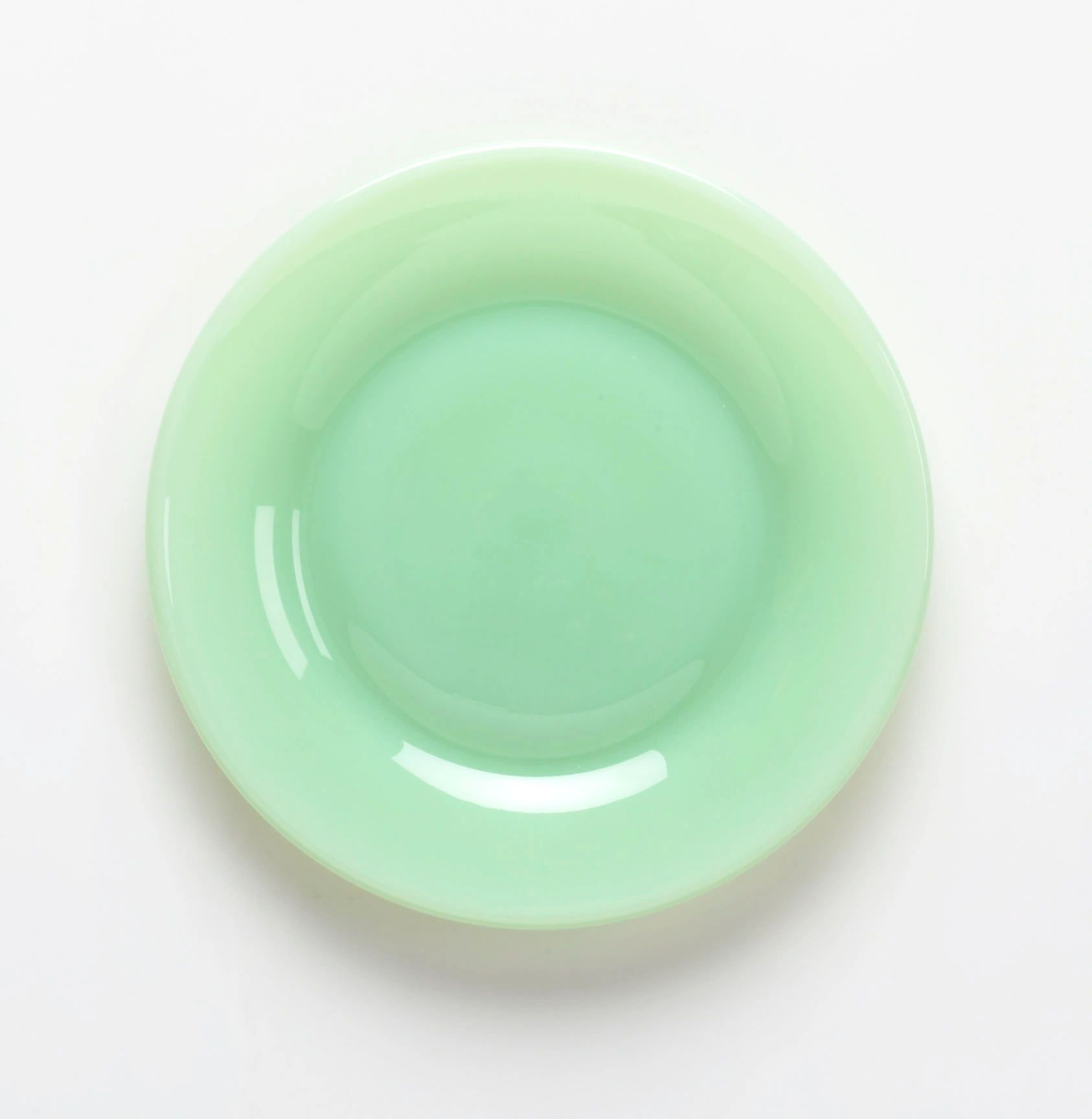A smooth, light green ceramic plate with a glossy finish.