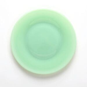 A round, mint-green plate with a smooth, glossy surface.