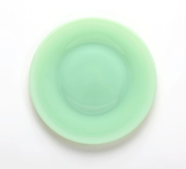 A round, mint-green plate with a smooth, glossy surface.