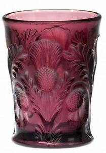 A deep red glass vase with intricate floral and leaf designs.
