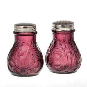 Pair of vintage purple glass salt and pepper shakers with metal tops.