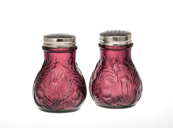 Pair of vintage purple glass salt and pepper shakers with metal tops.