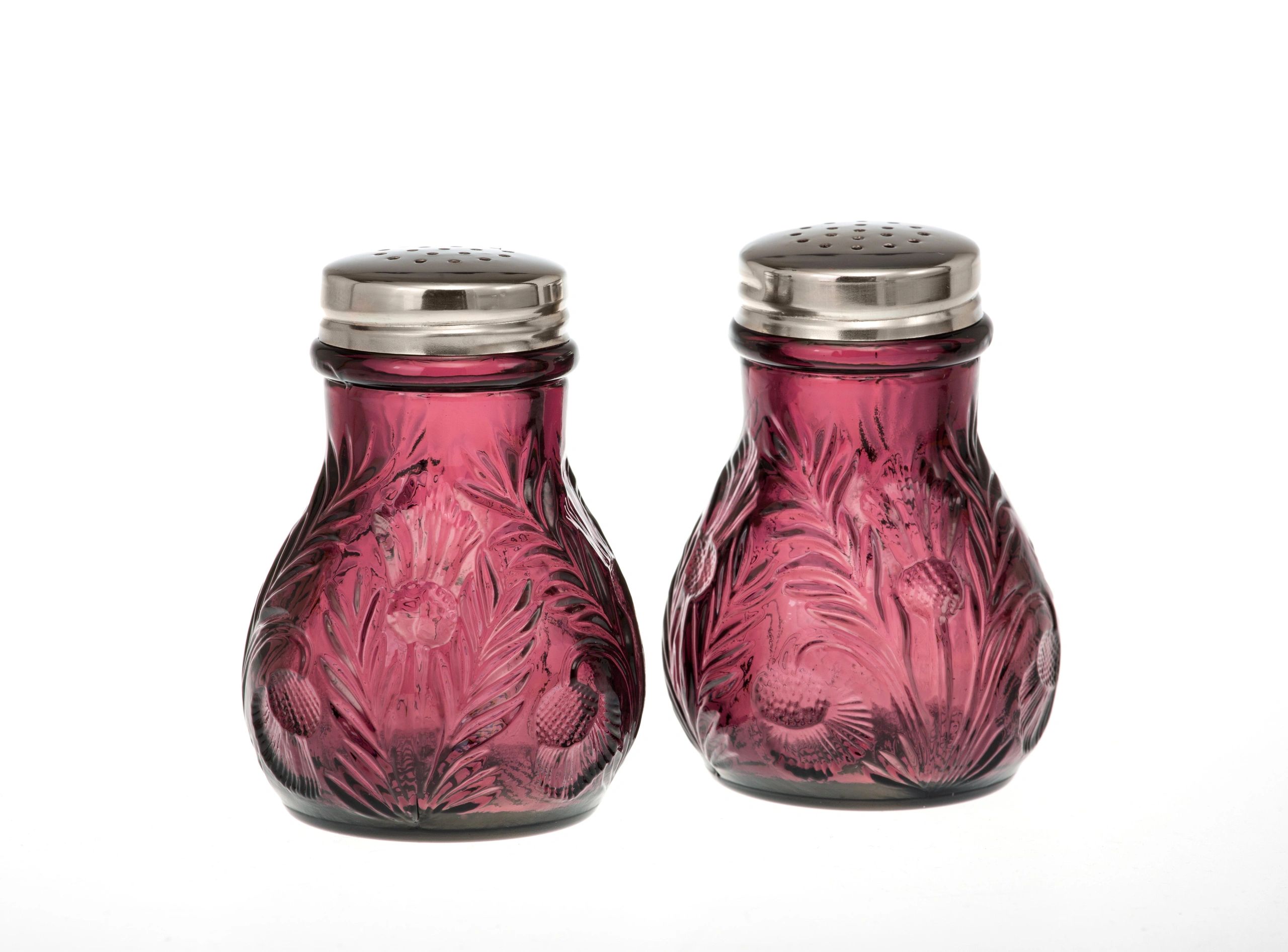 Pair of vintage purple glass salt and pepper shakers with metal tops.