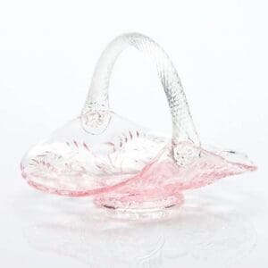 Delicate pink and clear glass basket with a curved handle.