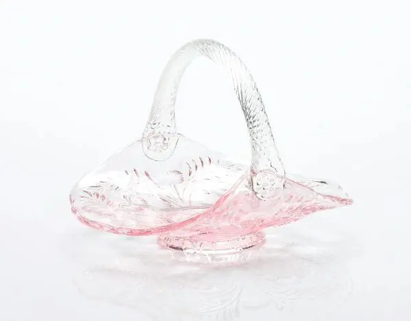 Delicate pink and clear glass basket with a curved handle.