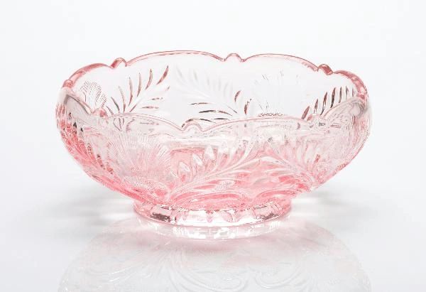 Elegant pink glass bowl with intricate floral patterns and scalloped edges.