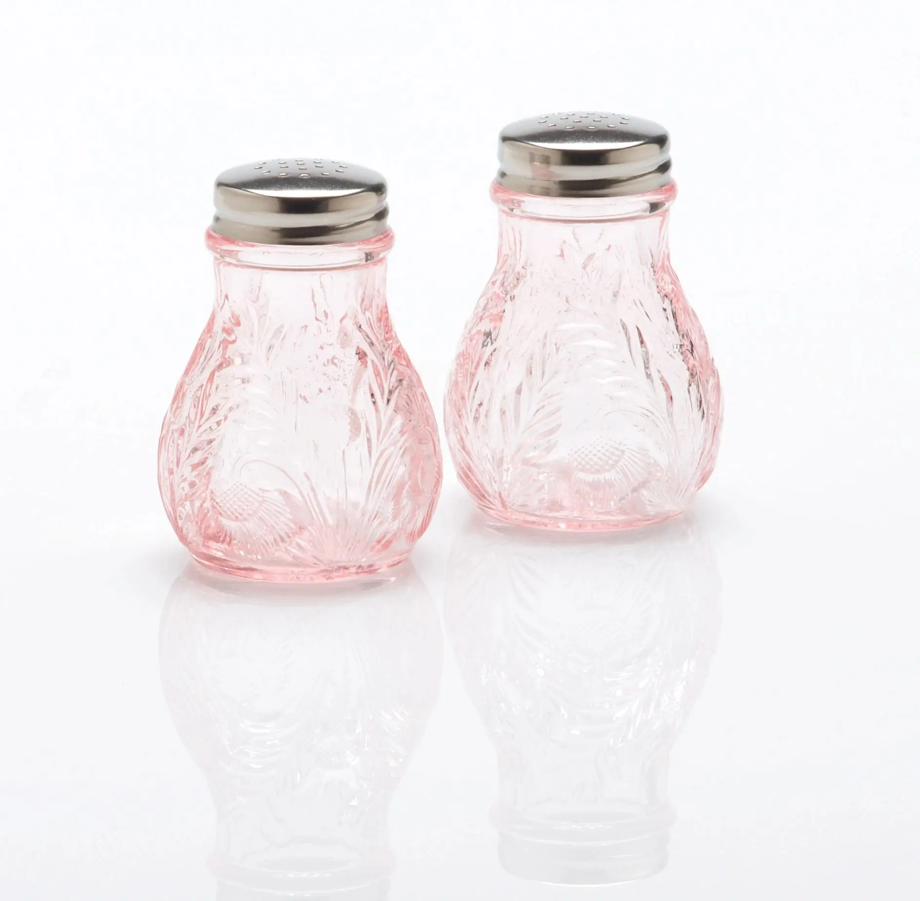 Pair of vintage-style pink glass salt and pepper shakers with metal lids.