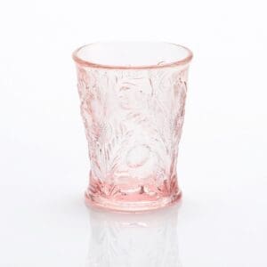 A translucent pink glass with intricate floral designs.