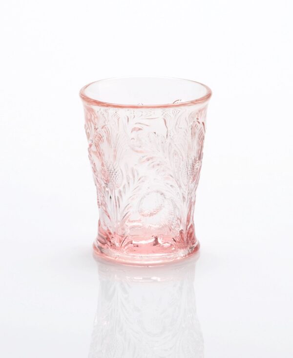 A translucent pink glass with intricate floral designs.