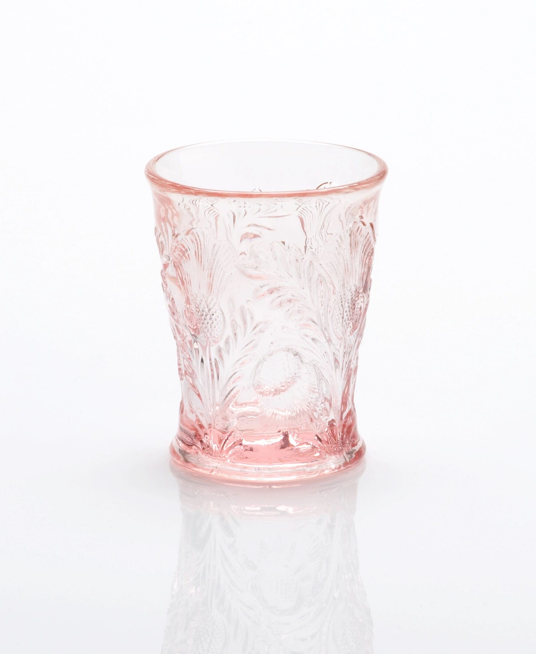 A translucent pink glass with intricate floral designs.