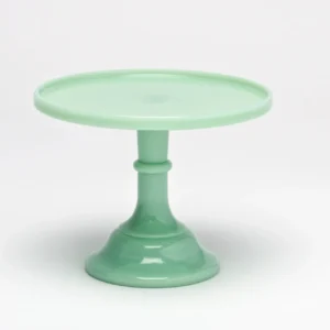 A pastel green ceramic cake stand with a wide base and round top.