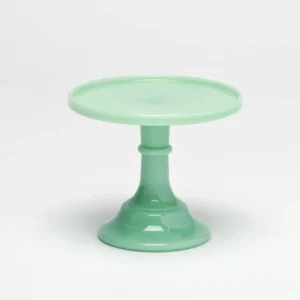 A mint green cake stand with a wide base and flat top.