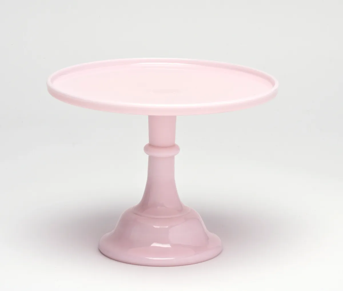 Elegant pink cake stand with a scalloped edge and pedestal base.
