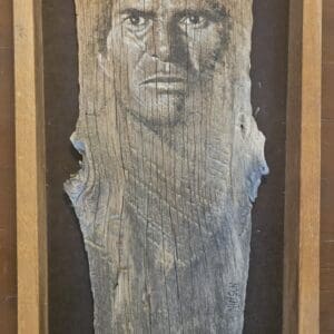 Portrait on weathered wood with rustic frame.