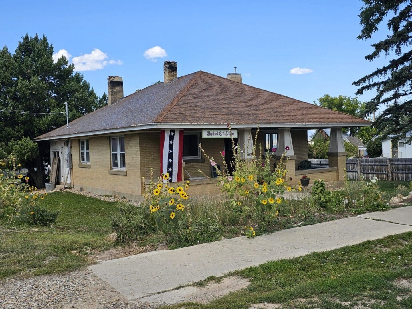 Single-story brick house with sunflowers
